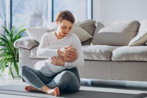 young-woman-breast-feeding-toddler-son-and-sitting-on-mat